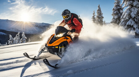 Athlete On A Snowmobile Moving In The Mountains At Sunset.